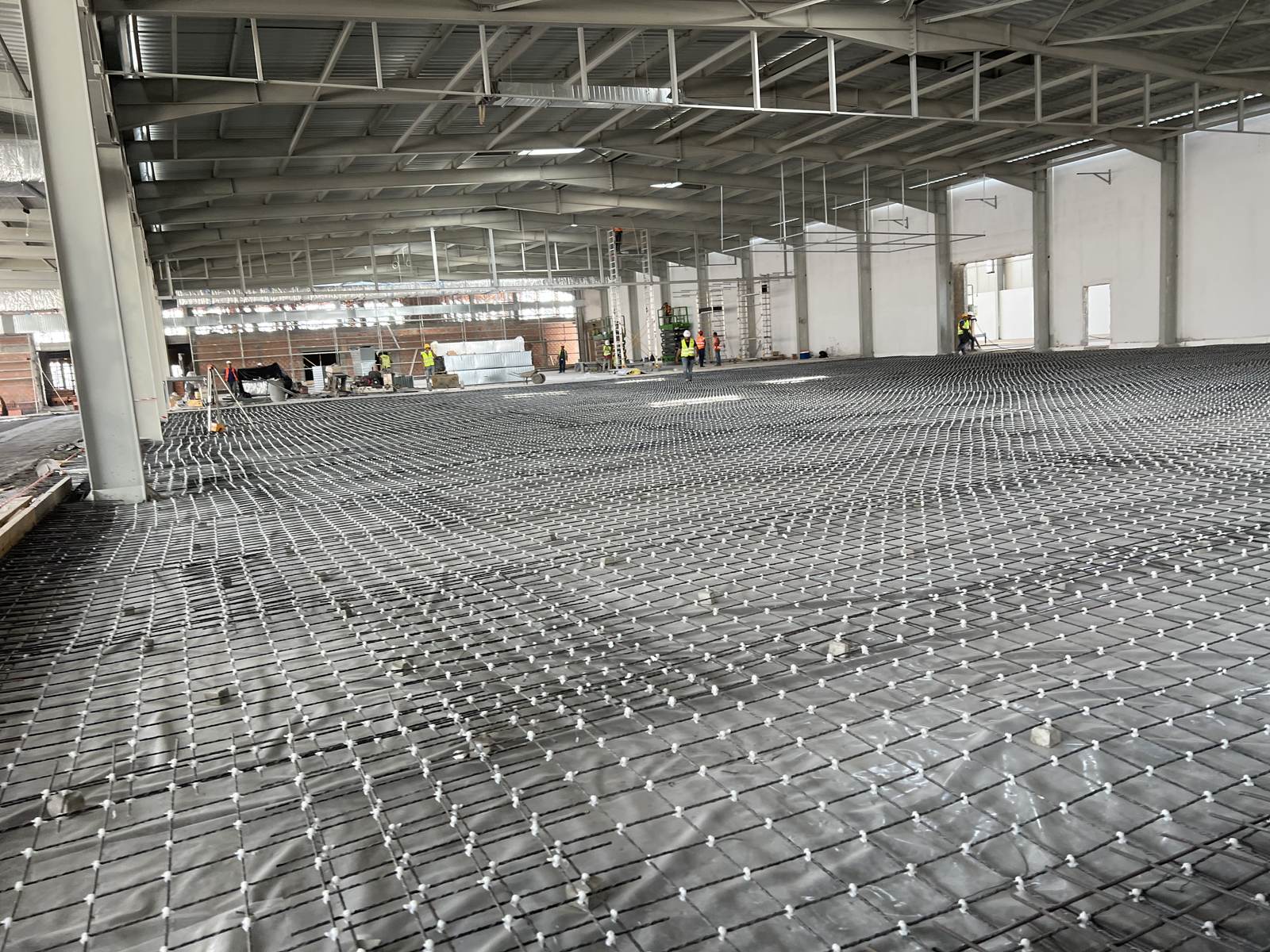 Mesh reinforcement laid across a large industrial floor slab