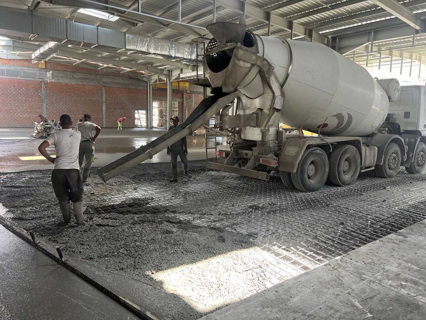 Concrete being poured over reinforcing mesh from a mixer truck